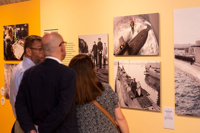 trois invités face aux photos de l'exposition 