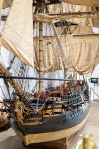 Large-scale wooden sailing ship model The ship has three masts and multiple sails made of beige fabric