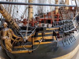 Large-scale wooden sailing ship model The ship has three masts and multiple sails made of beige fabric