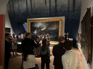 Les membres du cercle Neptune lors d’une visite guidée dans une salle du musée national de la Marine à Paris, devant une grande peinture de tempête en mer encadrée d’or. 