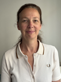 Portrait de Marion Veyssière en polo clair, souriante, sur fond neutre – photographie de Laurent Veyssière.