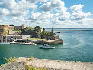 Vue sur le château de Brest, siège du musée national de la Marine, en bord de mer sous un ciel dégagé.