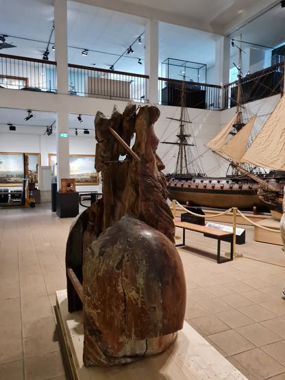 Figure de proue du Neptune exposée au musée national de la Marine à Toulon, vue de dos dans la salle des maquettes de navires.