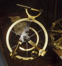Instrument de navigation ancien en laiton, de type cercle de réflexion, composé d’un grand anneau gradué avec lunettes de visée et mécanismes de réglage, présenté dans un coffret en bois.