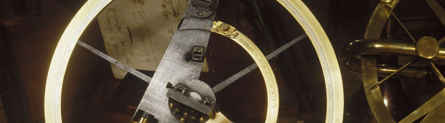 Instrument de navigation ancien en laiton, de type cercle de réflexion, composé d’un grand anneau gradué avec lunettes de visée et mécanismes de réglage, présenté dans un coffret en bois.