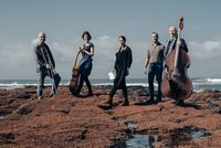 Le groupe Clover en bord de mer, avec instruments de musique et narratrice, interprétant Magellan de Stefan Zweig en concert littéraire.