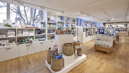 Vue d’ensemble de la boutique du musée national de la Marine avec présentoirs centraux et objets inspirés du patrimoine maritime.