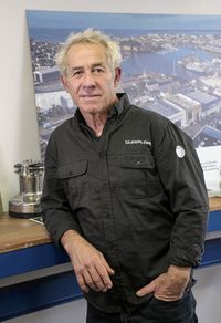 Portrait d’un homme du navigateur, devant des outils et du matériel technique.