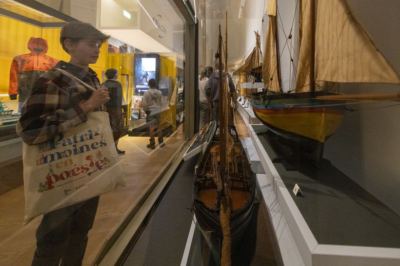 Un jeune lauréat face à une maquette de bateau