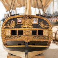 Modèle de poupe d’un vaisseau orné de dorures et sculptures marines exposé au musée national de la Marine à Paris.