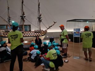 Groupe d’enfants du Secours populaire face au modèle du Royal Louis au musée national de la Marine.