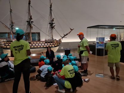 Groupe d’enfants du Secours populaire face au modèle du Royal Louis au musée national de la Marine.
