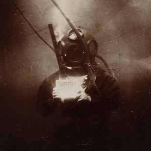 Photographie ancienne d’un scaphandrier en plongée équipé d’un scaphandre rigide relié à la surface, prise par Louis Boutan en 1898