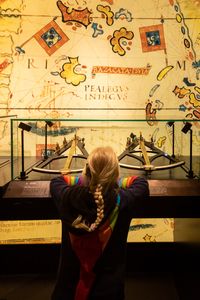 Petite fille devant une vitrine d'instruments de navigation