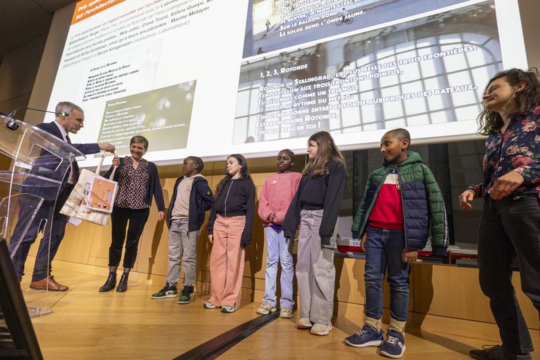 Le directeur remettant le prix, a une enseignante et ses élèves 