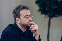 Portrait de Loïc Bienassis, assis et pensif lors d’une rencontre