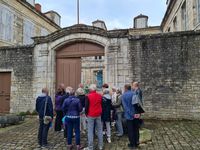 Visite guidée d’un groupe de personnes devant la porte en bois monumentale de l'hôtel d'Amblimont, lors des Journées européennes du patrimoine