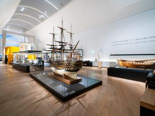 Vue de la galerie « Construire et instruire » au musée national de la Marine à Paris, avec des maquettes de navires exposées sous vitrines dans un espace muséographique lumineux.