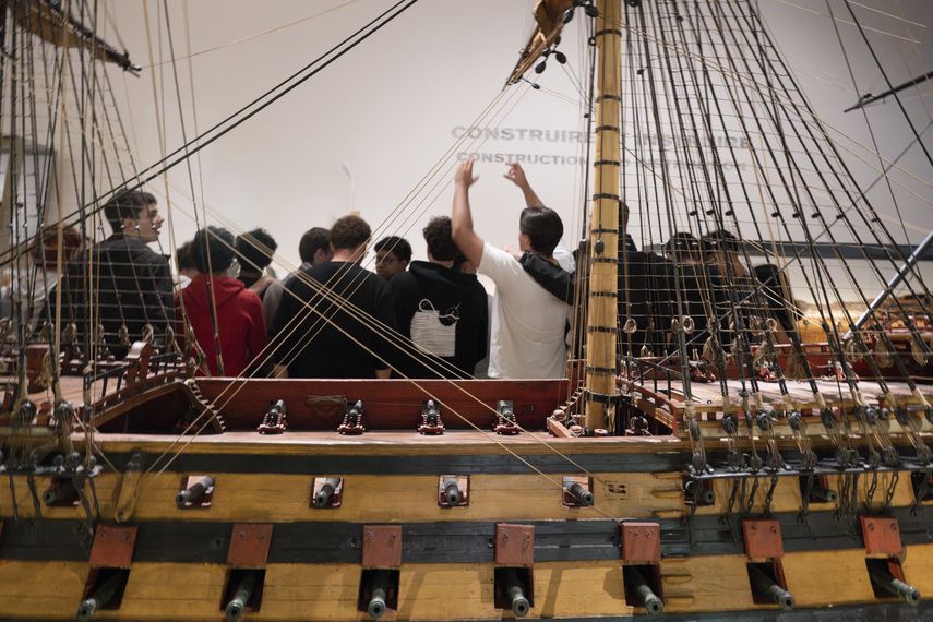 Groupe de lycéens découvrant une maquette de navire au musée national de la Marine à Paris.