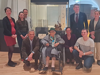 Groupe des équipes du musée posant autour de la vitrine du Normandie avec sculptures et dessins, lors de l’installation en présence de la fille de Carlo Sarrabezolles.