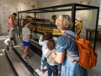 Famille avec enfants observant une maquette de navire ancien dans les collections permanentes du musée national de la Marine de Rochefort.