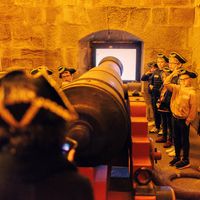 Enfants en chapeau d'officier devant un canon