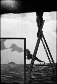 Photo en noir et blanc d'un homme sur une échelle