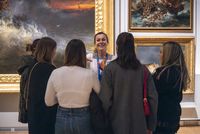 Médiatrice de face avec des visiteurs de dos