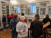 Groupe de visiteurs découvrant la bibliothèque et les collections scientifiques historiques de l’Ancienne école de médecine navale, à Rochefort.
