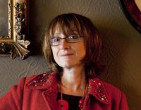 Photographie contemporaine d’une conférencière en veste rouge, intervenante de la conférence sur les exploratrices.