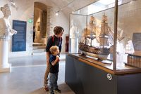 Enfant et sa mère face à la vitrine d'une maquette 