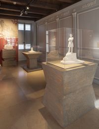 Salle d’exposition consacrée à Pierre Loti au musée national de la Marine de Rochefort, présentant des sculptures et objets dans une scénographie aux tons sobres et éclairages ciblés.