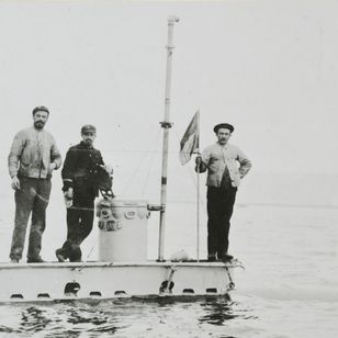 Le sous-marin Gymnote à fleur d'eau avec quatre marins sur le pont, photographie de 1888.