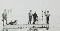 Le sous-marin Gymnote à fleur d'eau avec quatre marins sur le pont, photographie de 1888.
