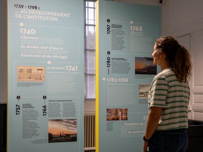 Visiteuse consultant des panneaux interactifs et contenus graphiques dans l’espace repère de l’École de médecine navale de Rochefort