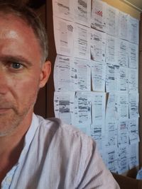 Photographie montrant une personne en premier plan, avec un mur couvert de dessins et de schémas visibles en arrière-plan.