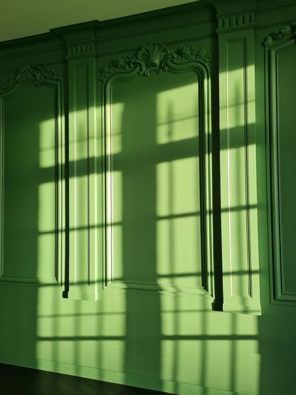 Fenêtres laissant entrer la lumière sur des murs intérieurs repeints en vert dans le musée national de la Marine à Rochefort.