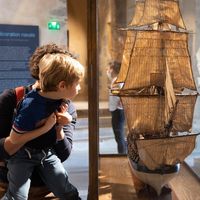 Enfant regardant une maquette porté par son parent 