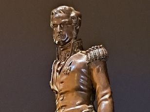 Statuette en bronze de l’explorateur Jules Dumont d’Urville debout sur un socle, présentée dans les collections du musée national de la Marine
