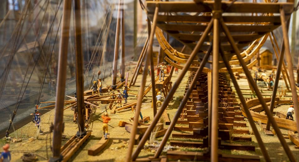 A miniature model of a shipyard with a wooden ship under construction
