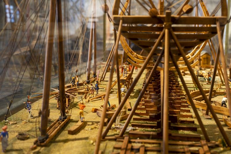 A miniature model of a shipyard with a wooden ship under construction