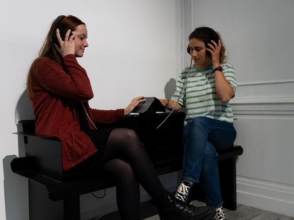 Deux visiteuses écoutent des témoignages sonores à une station d’écoute interactive du Musée national de la Marine, à Rochefort.