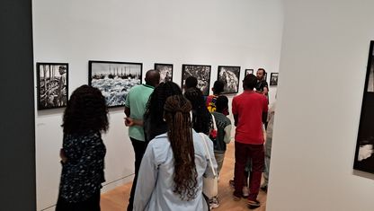 Visite guidée de l’exposition « Jean Gaumy et la mer » au musée national de la Marine – un groupe de visiteurs observe des photographies exposées 