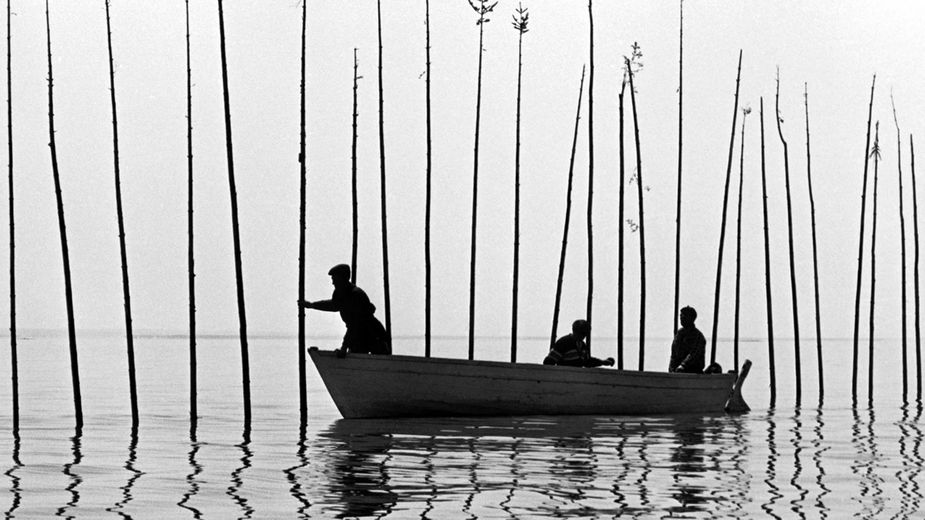 Photo en noir et blanc de pêcheur sur une barque