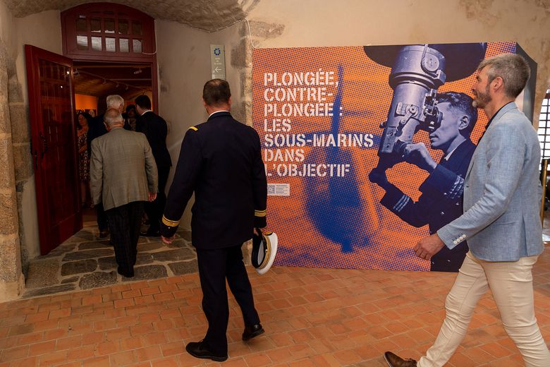 Entrée des premiers invités avec vue sur le panneau d'entrée de l'exposition 