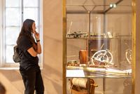 Visiteuse observant une vitrine d’instruments scientifiques et de navigation anciens – photo Brumes Editions, 2024.