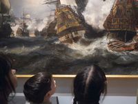 Trois jeunes enfants regarde un tableau de bataille