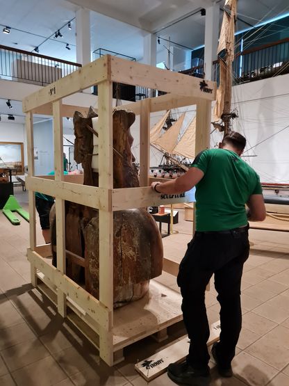 Emballage de la figure de proue du Neptune dans une caisse en bois avant son départ pour Les Franciscaines à Deauville.