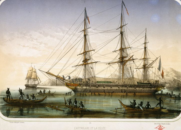 Deux grands navires à voiles vus de profil, au mouillage dans une baie calme, entourés de petites embarcations sur l’eau.