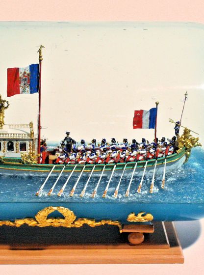 Maquette du canot impérial de Napoléon Ier réalisée dans une bouteille en verre, avec rameurs et pavillons français.